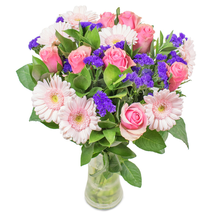 This elegantly arranged bouquet from the heart of St John's Wood features a sophisticated blend of seasonal florals, thoughtfully gathered in a clear, polished glass vase. Seven-to-nine medium pink roses, many still teasing with their tightly curled centers, invite moments of quiet admiration, while five-to-seven pale pink gerbera daisies with generous, radiating petals and soft centers add an airy delicacy. Lively clusters of deep purple statice provide striking contrast and texture, scattered artfully throughout the arrangement. Beneath and around each bloom, opulent green foliage gives an abundant, fresh look reminiscent of local gardens in spring bloom. The vase's transparency showcases the sturdy, fresh stems and the clarity of just-poured water, underscoring the bouquet's sense of quality and local freshness. Perfect for celebrating milestones like birthdays, Mother's Day, or simply adding a refined accent to a St John's Wood living room, this bouquet speaks of joy, gratitude, and daily celebration, delivered with care and local flair.